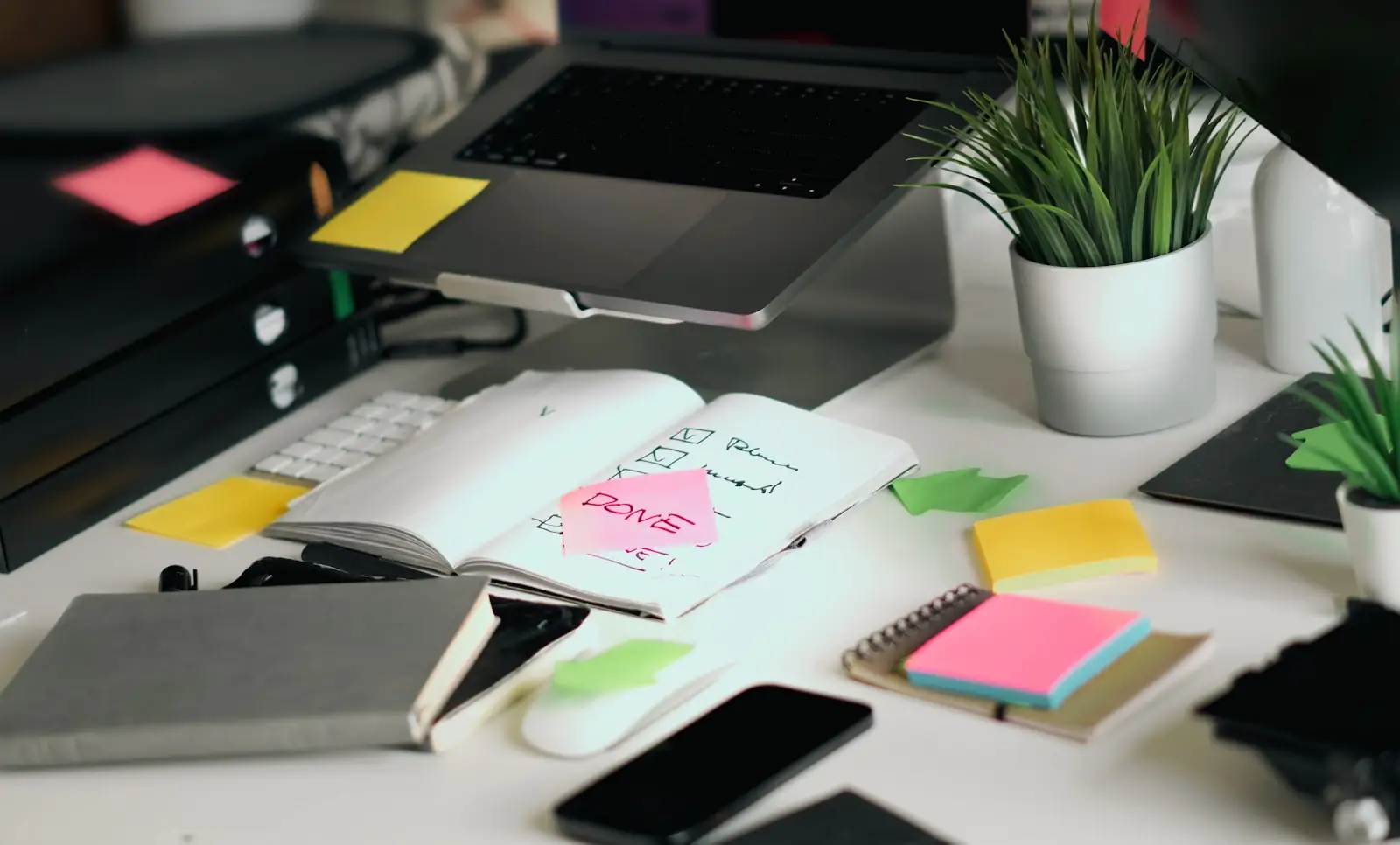 A desk workspace with a notebook, laptop, and phone, representing the four-step playbook for turning a brand into a content studio.